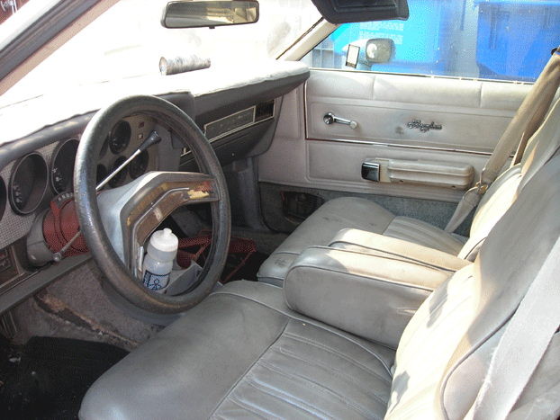 Tan bucket-seat interior with sport steering wheel of an older vehicle