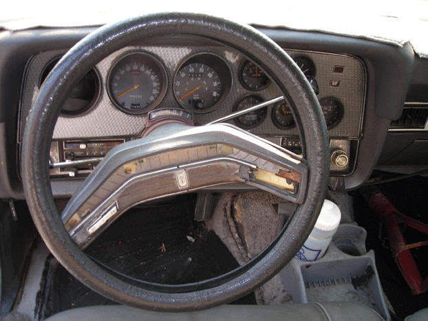 Interior shot of a car's dashboard, showing the steering wheel and gauges