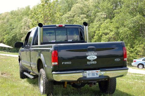 1979 Ford Bronco - This black Ford F-250 pickup truck features prominent dual exhaust stacks and a custom decal on the tailgate.