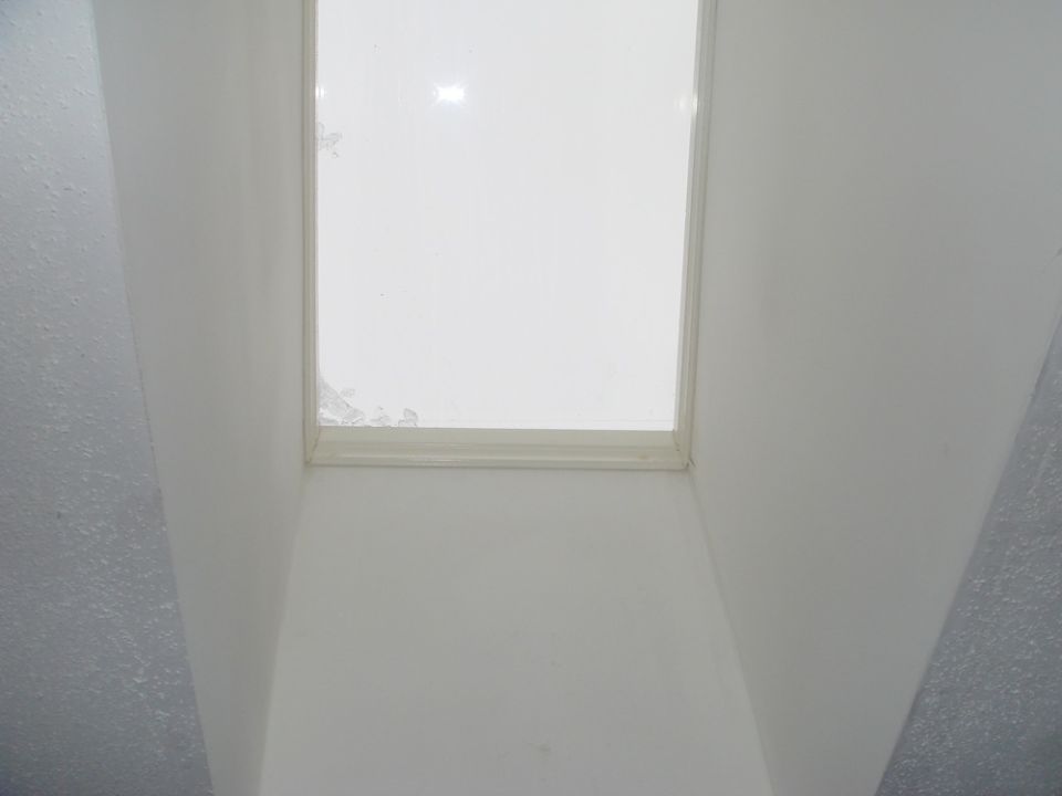 Interior shot looking up at a skylight with some damage around the edges