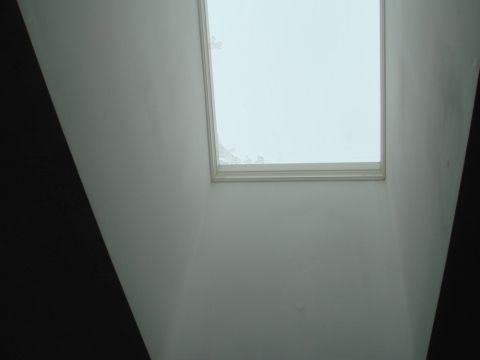 1996 Ford Bronco - A view of a skylight from inside a room, showing its frame and the sky above.