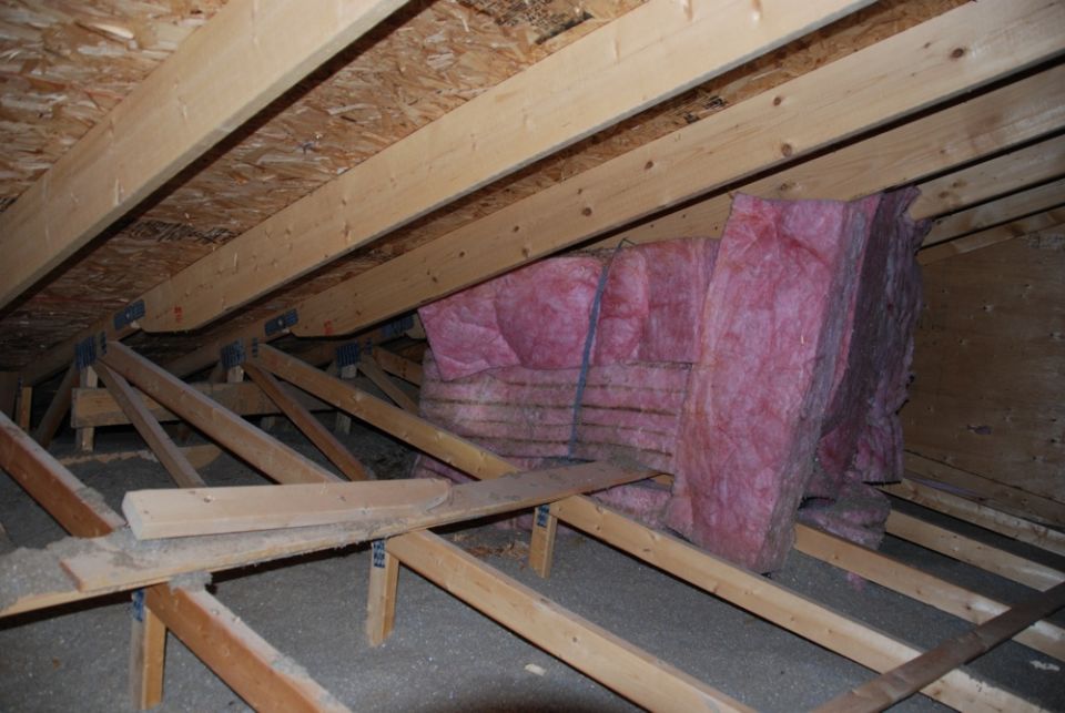 attic framing with pink fiberglass insulation