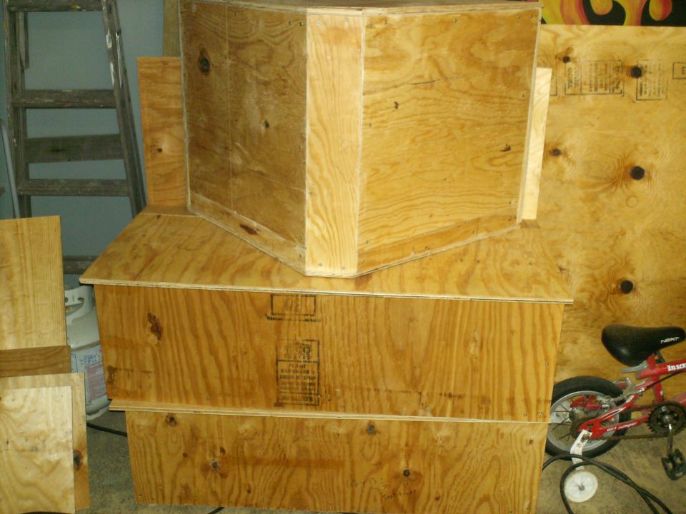 Stacked plywood crates with a red bicycle on the right