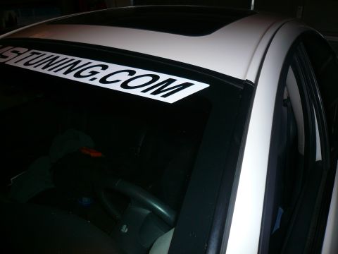 1996 Ford Probe - A white car's windshield displays a banner with the text "US TUNING.COM" across the top.