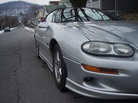 2000 Chevrolet Camaro - A silver 2000 Chevrolet Camaro is parked on a residential street with snow on the ground.