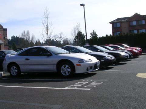 2007 Mazda 3 - Several coupes are parked in a lot on a sunny day.