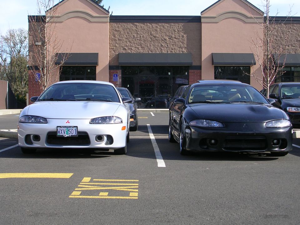 Silver Mitsubishi Eclipse with license plate HXV 501 parked next to a black one