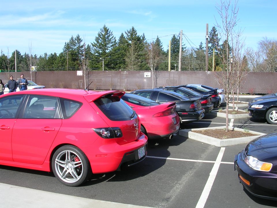 Red 2007 Mazda 3 hatchback parked in a lot, rear view