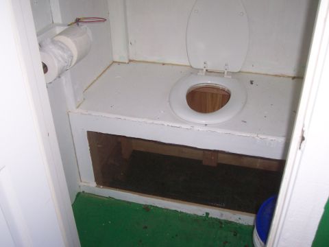 1994 Ford F-150 - This image shows the interior of a small room with a toilet and a roll of toilet paper mounted on the wall.
