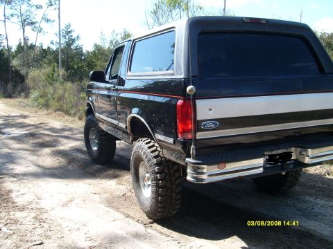 1992 Ford Bronco - This lifted 1992 Ford Bronco is shown from the rear quarter on a dirt road.