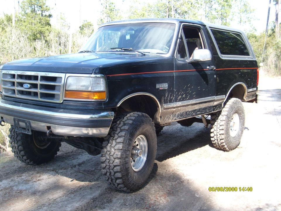 Black 1992 Ford Bronco with lifted suspension and off-road tires, viewed from a 3/4 front angle
