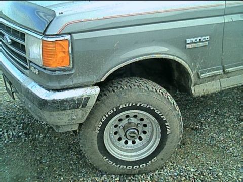 1989 Ford Bronco - Close-up of a 1989 Ford Bronco's front fender and tire, showing the 'Bronco' badge.