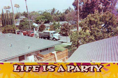 1989 Ford F-250 - Two dump trucks are visible on a street in a suburban neighborhood, with houses and trees in the background.