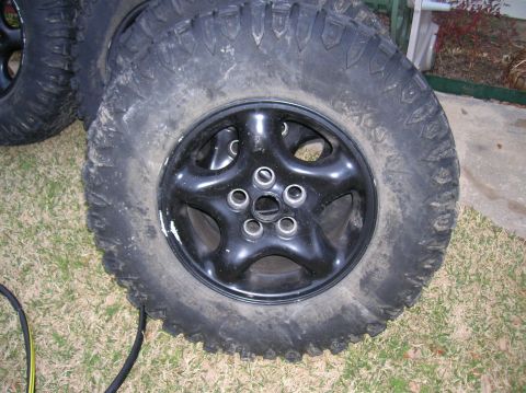 1999 Land Rover Discovery II - A close-up view of a black alloy wheel fitted with an off-road tire.