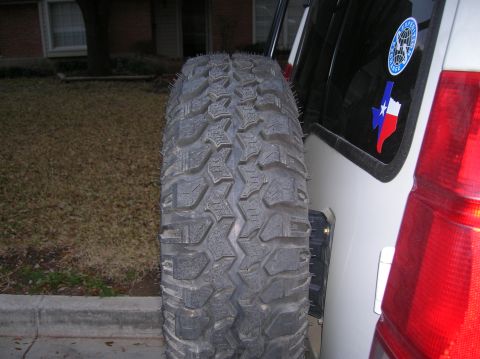 1999 Land Rover Discovery II - A close-up of a spare tire mounted on the back of an SUV, showing its tread pattern and a Texas flag sticker.