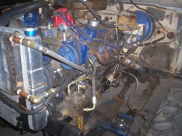 Engine bay with blue engine block, red distributor cap, and aluminum radiator