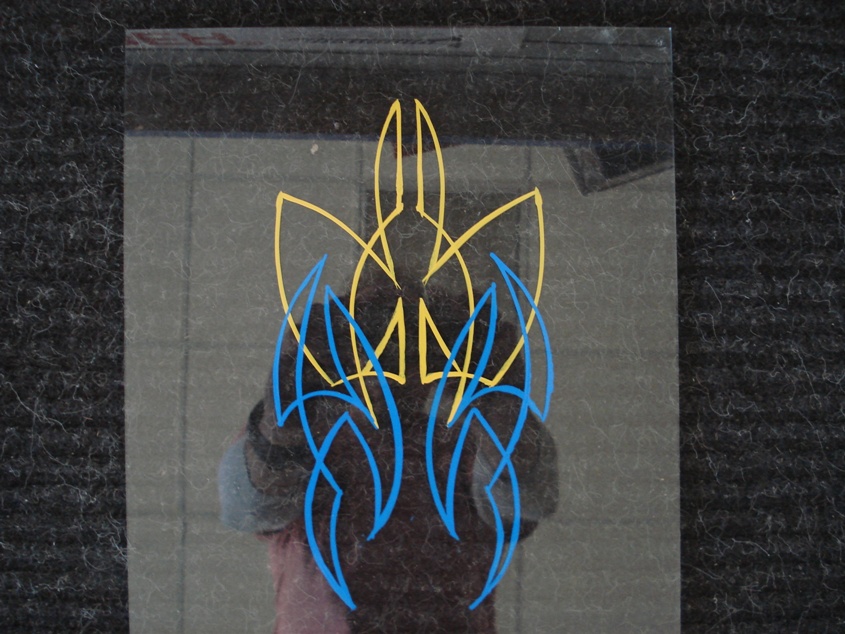 Pinstripe decal with blue and yellow flames on a reflective surface