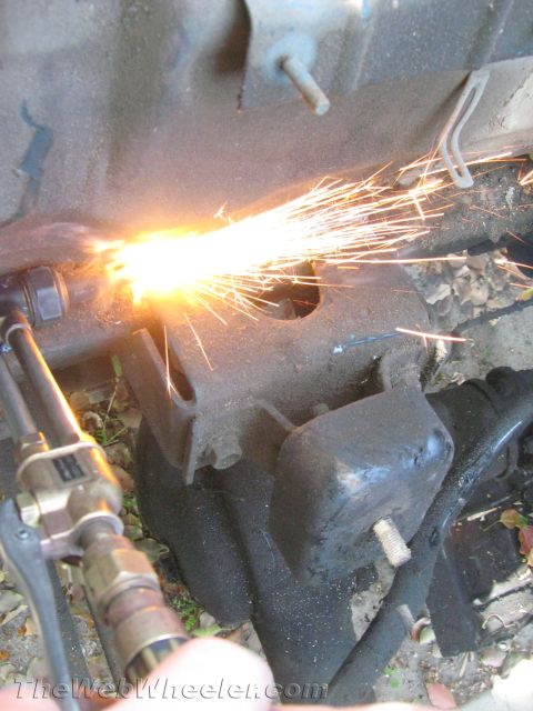 1987 Suzuki Samurai - Metal is being cut with a torch, creating a shower of sparks.