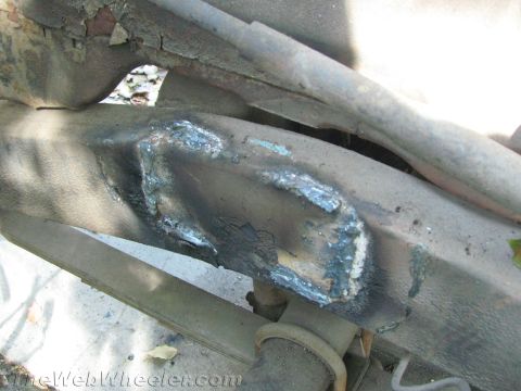1987 Suzuki Samurai - Close-up view of a vehicle's frame showing areas of rust and recent, crude welding repairs.