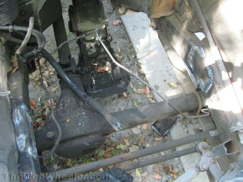 1987 Suzuki Samurai - Undercarriage view of vehicle drivetrain components, with visible rust and repair work on the frame.