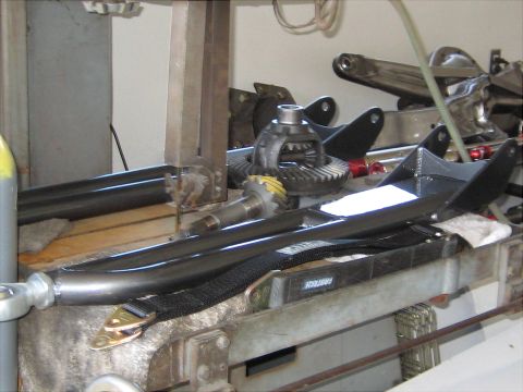 1996 Ford Bronco - Various automotive parts, including a differential and suspension components, are laid out on a workbench.