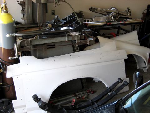 1996 Ford Bronco - White fender and suspension parts are laid out in a workshop.