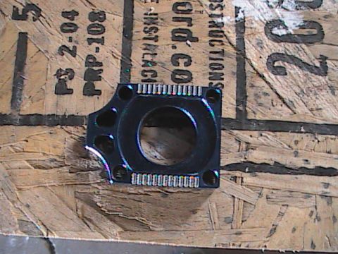 2007 Yamaha YZ450F - Black motorcycle part with circular opening sits on a wooden surface with visible text.