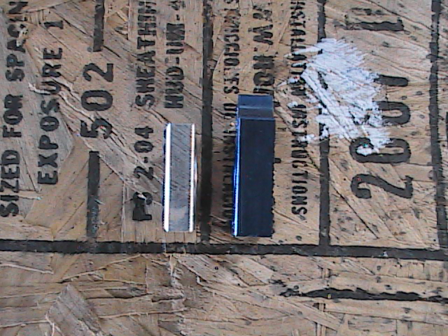 Two metal parts on plywood with 2004 date stamp