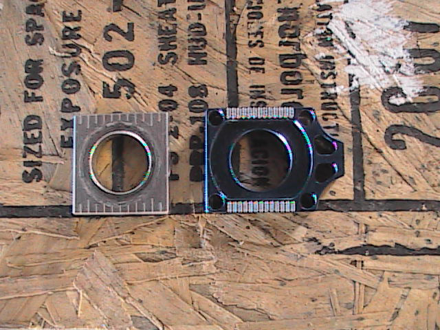 Two motorcycle parts, one with a ruler, on a wooden surface with text