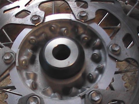 2007 Yamaha YZ450F - Close-up view of a motorcycle's wheel hub, spokes, and brake rotor, with visible text on the hub.