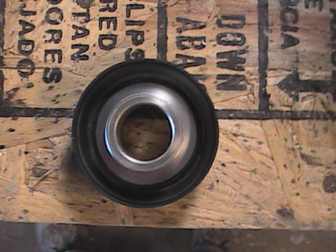 2007 Yamaha YZ450F - A metal bearing with a black rubber seal is shown on a piece of plywood.