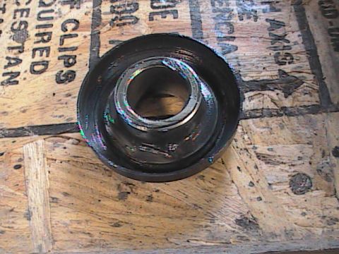 2007 Yamaha YZ450F - A metal part, possibly a bearing or bushing, rests on a wooden surface with visible text.