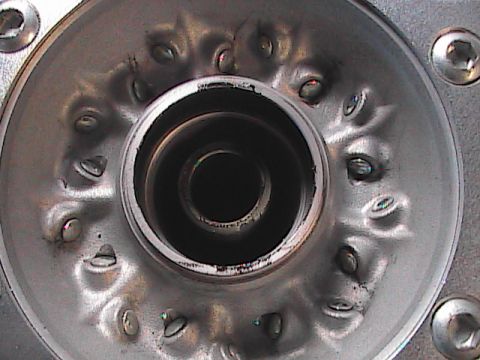 2007 Yamaha YZ450F - Metal component detail with a central hole and surrounding fasteners.