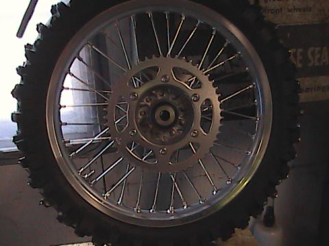 2007 Yamaha YZ450F - A close-up view of a motorcycle's rear wheel, tire, and sprocket.