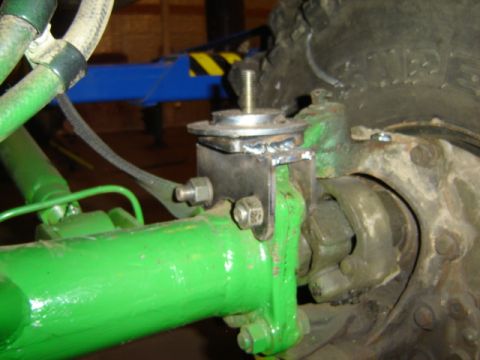 1992 Ford Bronco - Close-up of a green suspension component with a custom metal bracket attached.