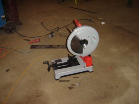 1992 Ford Bronco - A chop saw sits on a concrete floor, surrounded by tools and electrical cords.