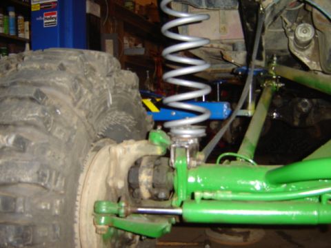 1992 Ford Bronco - This image shows the heavy-duty suspension and large tire of an off-road vehicle, likely undergoing modification or repair.