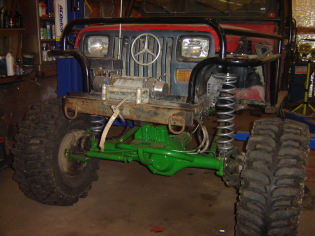 Modified off-road vehicle with a Mercedes-Benz grille emblem, winch, and green-painted suspension components