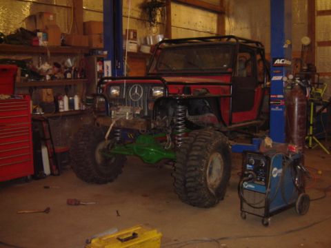 1992 Ford Bronco - Modified off-road vehicle with custom roll cage and large tires, a Mercedes-Benz emblem on the grille.