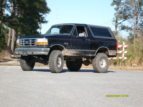 1992 Ford Bronco - This lifted 1992 Ford Bronco is shown in a 3/4 front view, with mud splatters on its side.