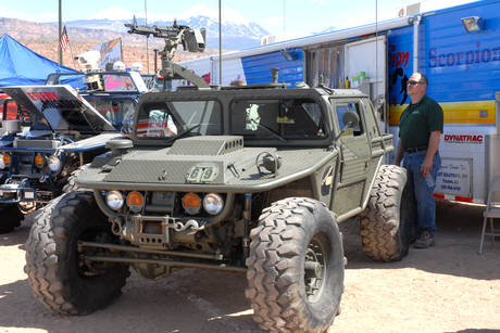 1985 Ford Bronco - This military-style vehicle, equipped with a mounted machine gun, is seen alongside another vehicle and a trailer.