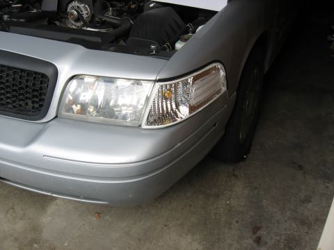 2004 Ford Crown Victoria - Front view of a 2004 Ford Crown Victoria with the hood raised, revealing the engine bay.