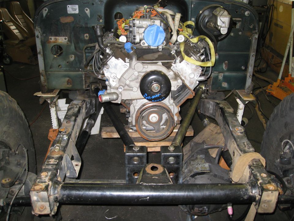 Jeep YJ frame with engine mounted on wooden blocks, front suspension visible