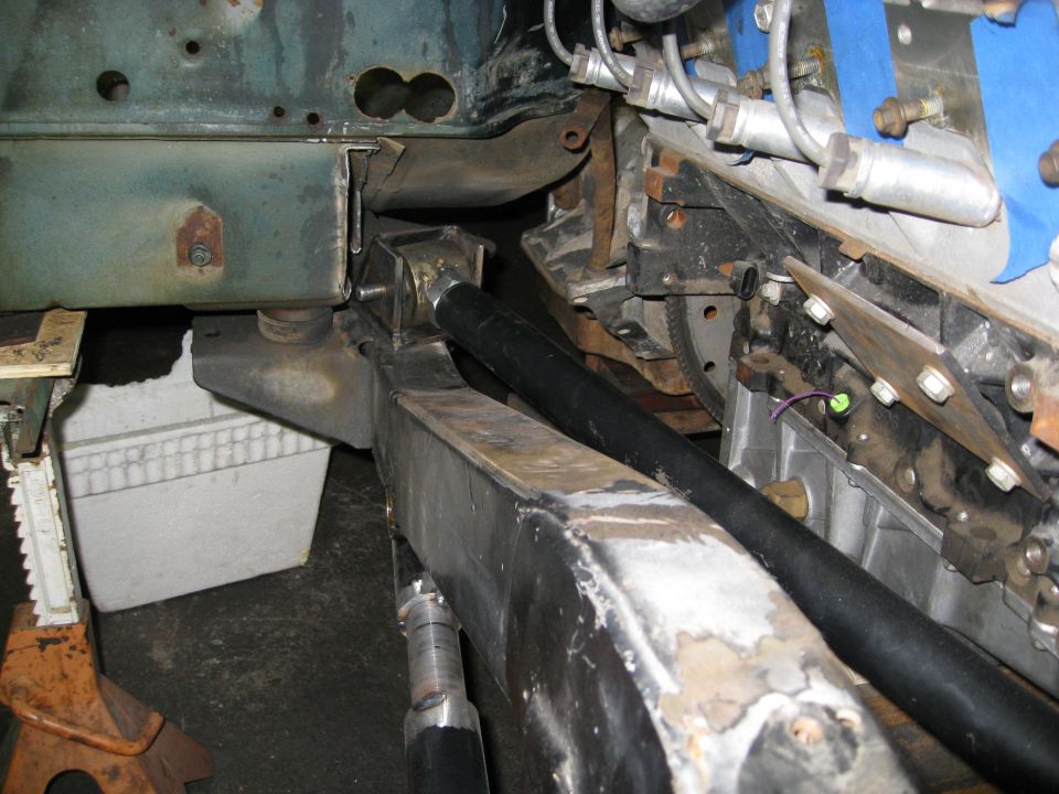 Custom frame work with engine components and suspension parts visible. Vehicle is on jack stands
