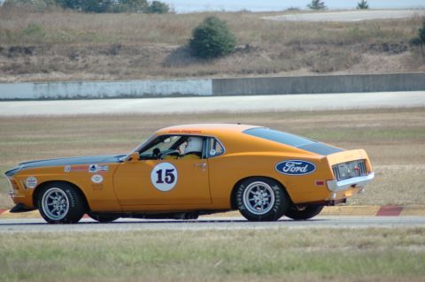 1970 Ford Mustang - A 1970 Ford Mustang race car with the Ford logo on its rear quarter panel is seen from the side on a track.