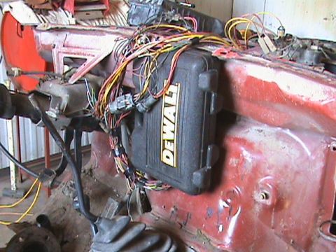 1987 Ford Bronco - A complex wiring harness is visible, along with a DeWalt toolbox, in the interior of a vehicle undergoing work.