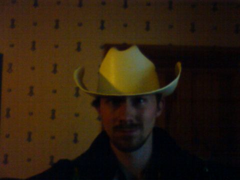 1989 Ford Bronco - Man wearing a yellow cowboy hat indoors with patterned wallpaper.