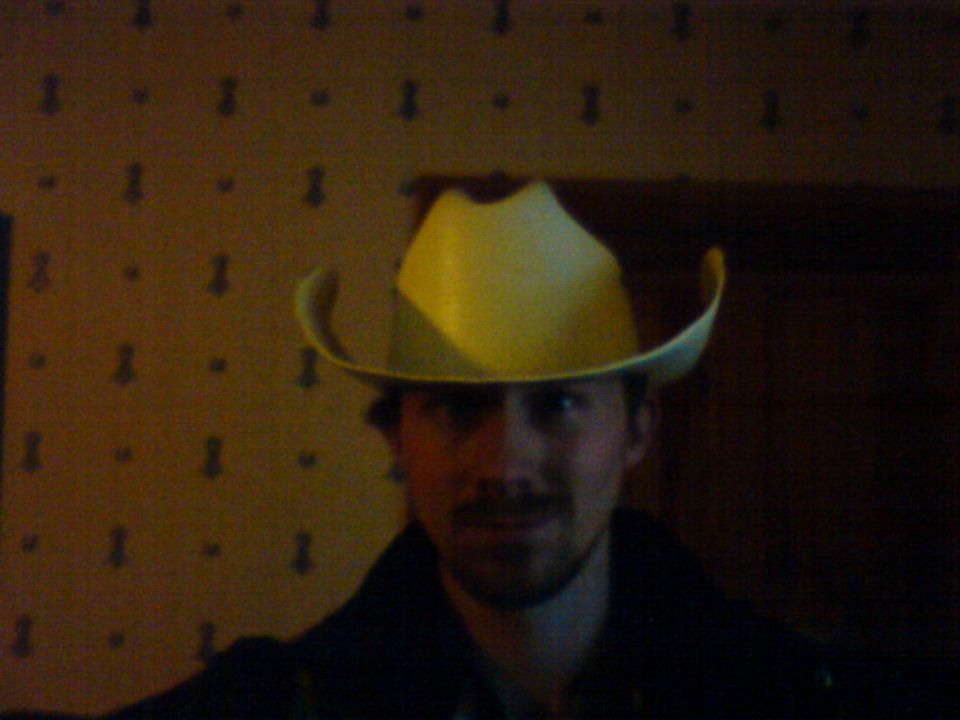 Man wearing a yellow cowboy hat indoors