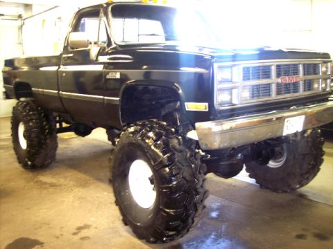 1984 GMC Sierra 3500 - This lifted 1984 GMC Sierra 3500 pickup truck features prominent off-road tires and a classic grille design.