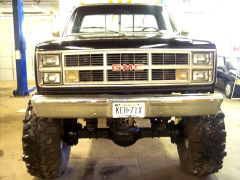 1984 GMC Sierra 3500 - This lifted GMC pickup truck features a prominent grille and large tires, seen from the front.